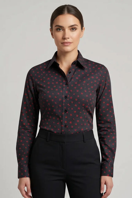 Woman wearing a dark patterned shirt and black pants on a gray background