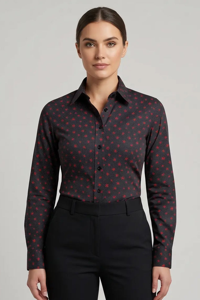 Woman wearing a dark patterned shirt and black pants on a gray background