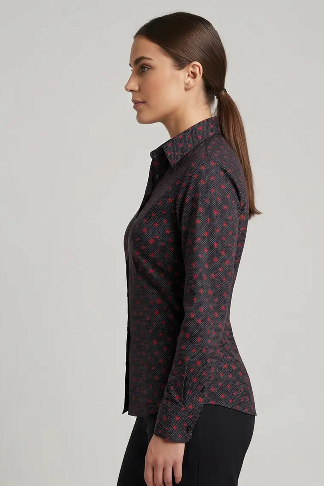 Woman wearing a dark patterned blouse against a gray background
