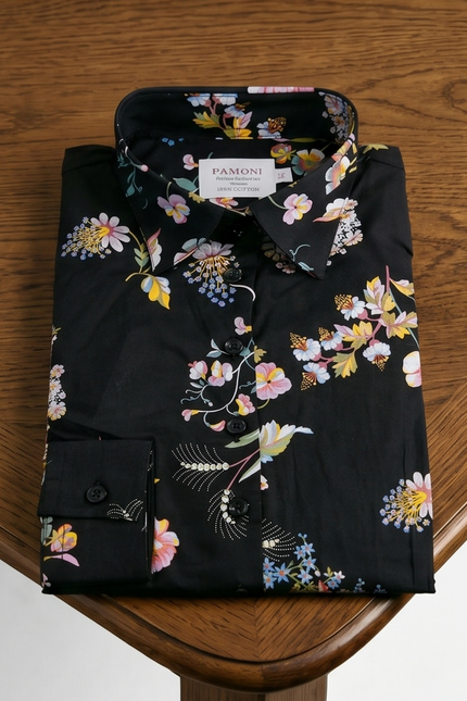 Folded black floral shirt on a wooden surface