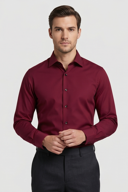 Man wearing a burgundy dress shirt against a plain background