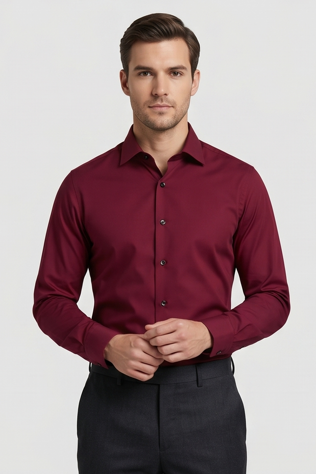 Man wearing a burgundy dress shirt against a plain background