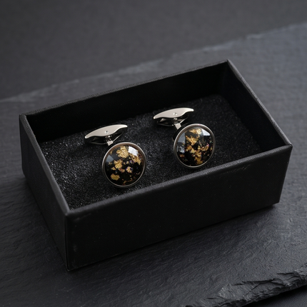 Cufflinks with floral design in a black box on a dark surface
