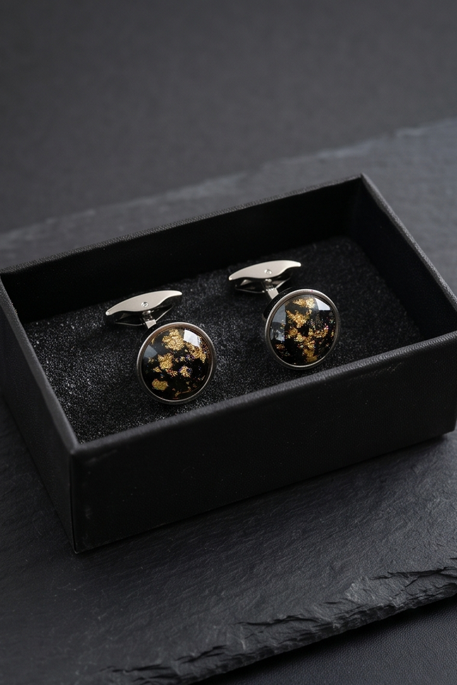 Cufflinks with floral design in a black box on a dark surface