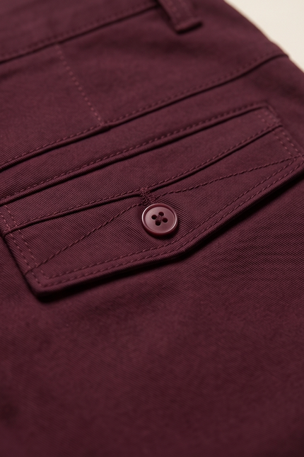 Close-up of a maroon pocket with a button on a matching garment.