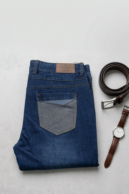 Folded blue jeans with a brown belt and watch on a light gray background