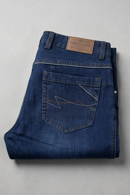 Folded blue jeans with a brand label on a light gray background