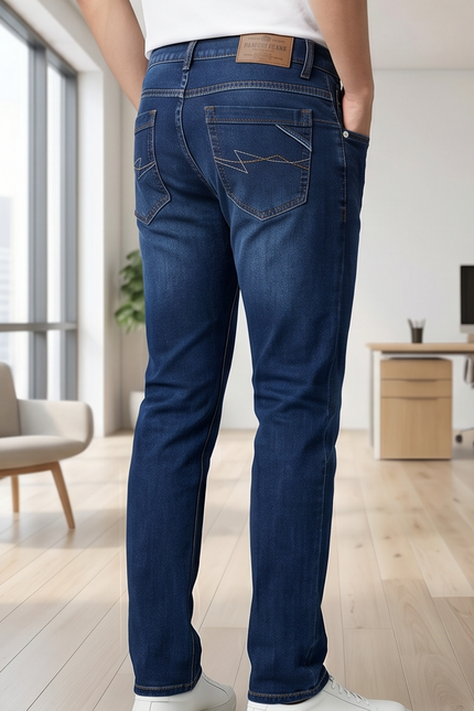 Person wearing blue jeans in a modern office setting