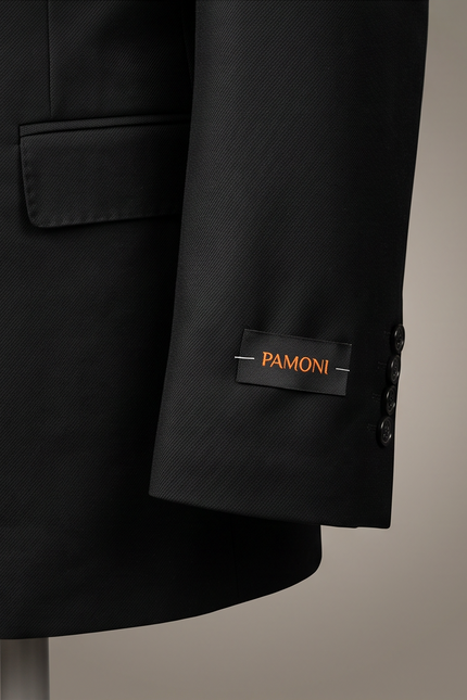 Close-up of a black PAMONI blazer sleeve with a black brand label featuring orange lettering, set against a neutral beige background.