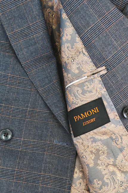 Close-up of a double-breasted suit jacket in a blue-gray plaid pattern, paired with a matching paisley necktie. A black brand label reading 'PAMONI LUXURY' is visible on the tie.